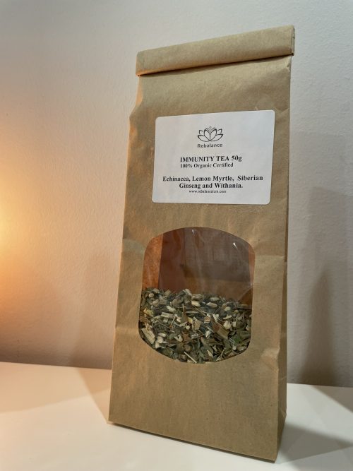 A bag of Immunity Tea next to a candle on a table.