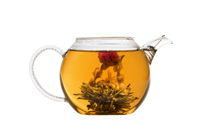A teapot with a flower in water in it. 