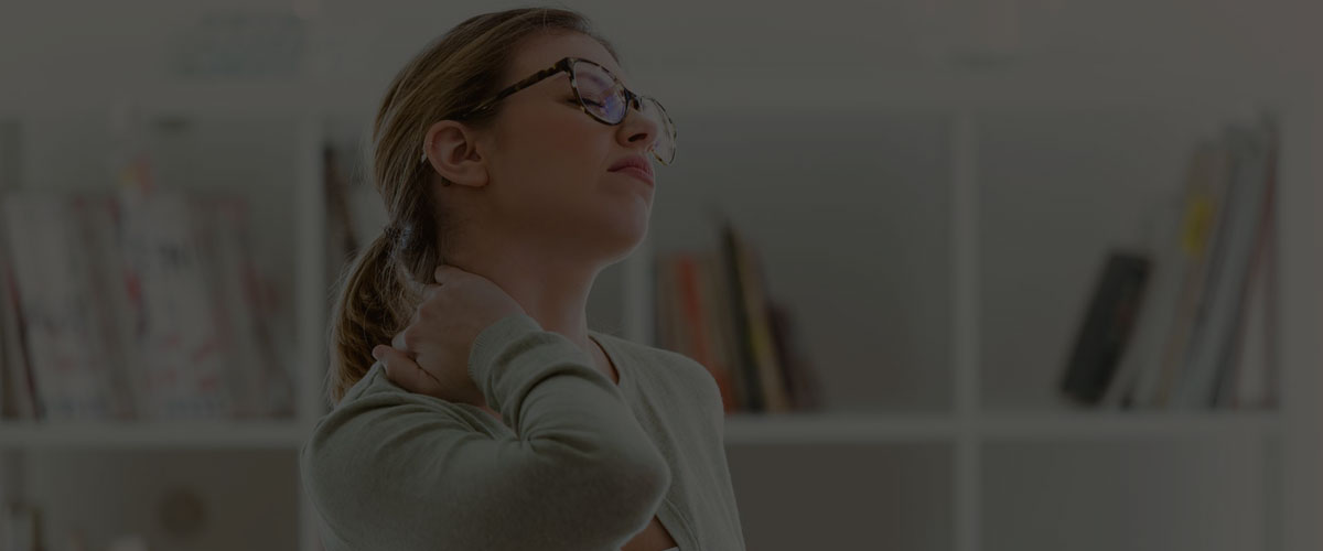 A woman with neck pain is sitting at a desk seeking pain management.